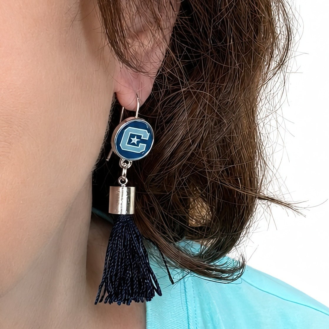Block C and Star Citadel earrings with dark blue tassels and silver-tone caps, on a model