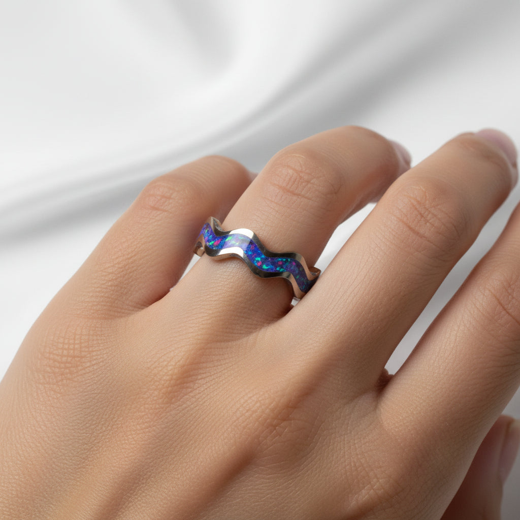 Let's Make Some Waves titanium stackable ring worn on a hand, showing the sculpted wave profile and colorful crushed opal inlay.