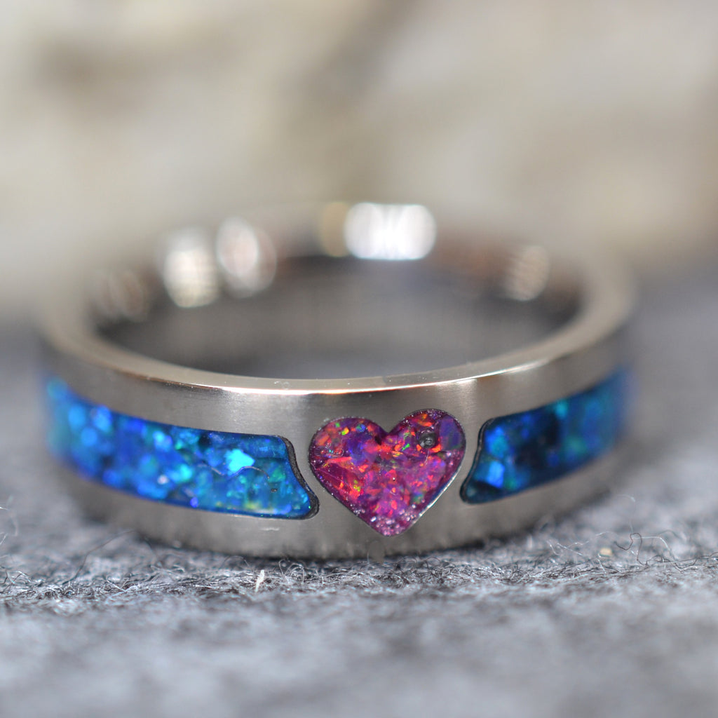 Custom titanium heart opal ring with a pink crushed opal heart and blue opal band inlay.