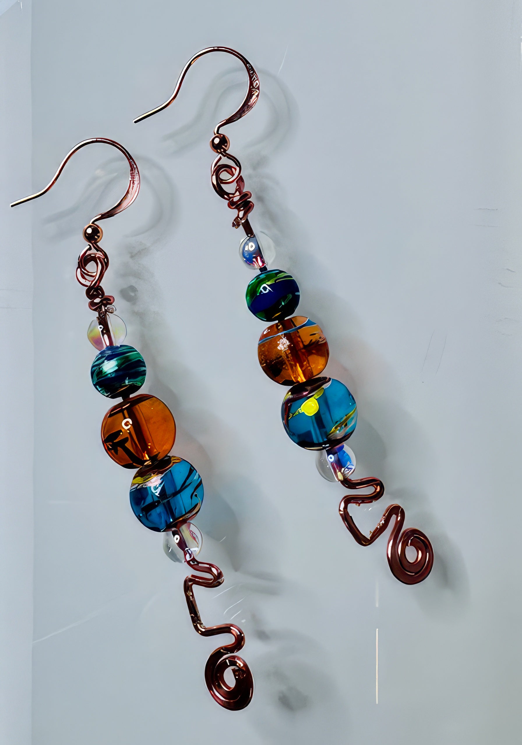 A pair of earrings featuring freeform copper wire design with colorful glass and clear beads.