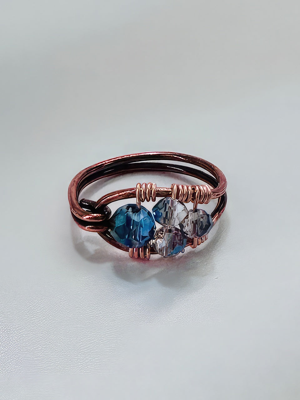 Hand formed treated copper ring with hand wired blue faceted stones for a unique statement ring