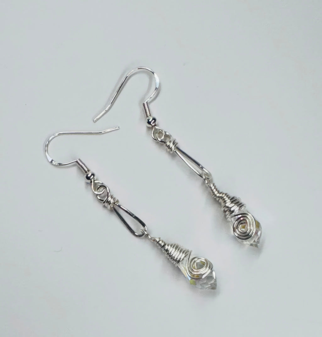 A pair of silver-colored wire earrings with faceted clear briolettes