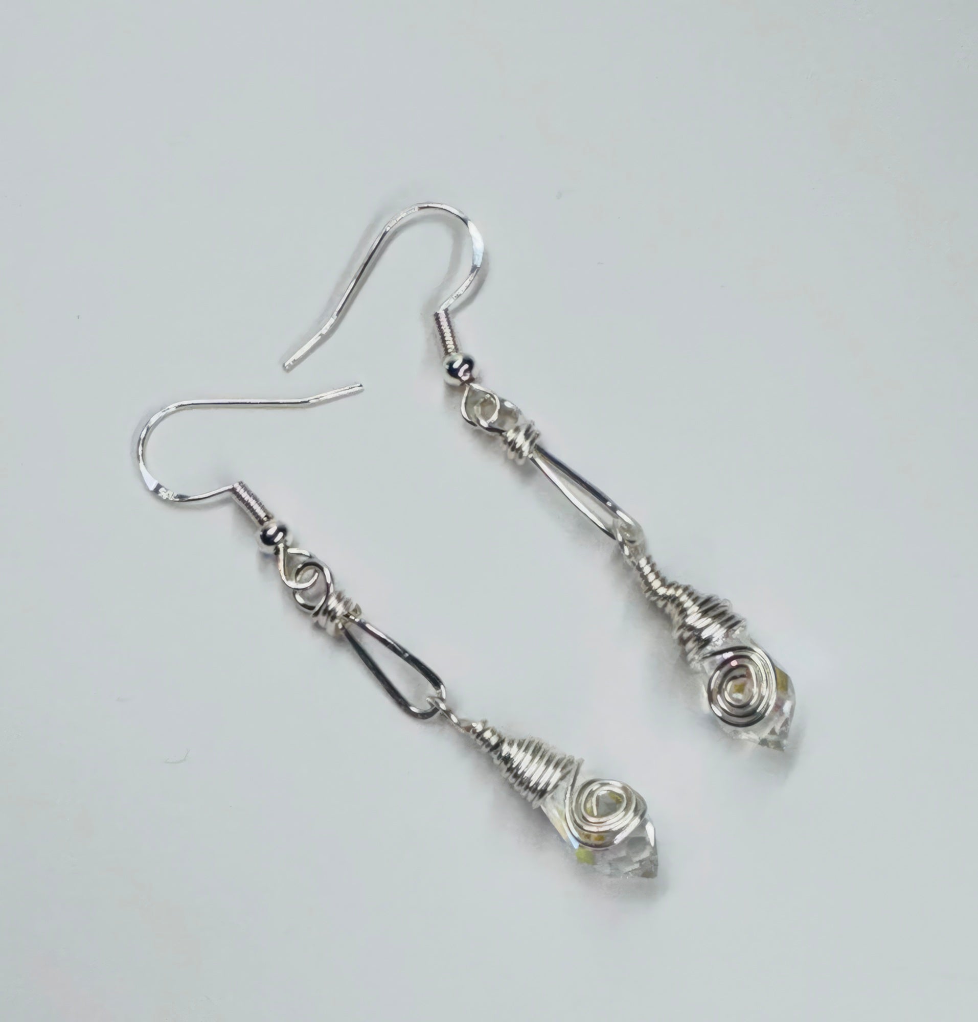 A pair of silver-colored wire earrings with faceted clear briolettes
