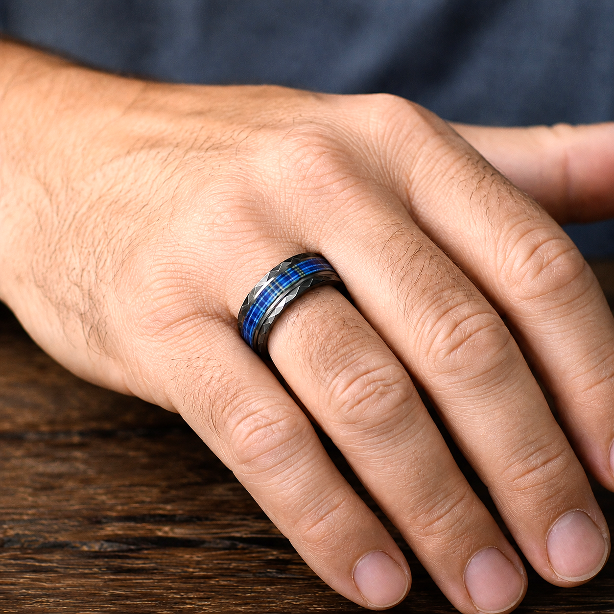 Man wearing a hand-burnished black hammered tungsten ring with The Citadel tartan inlay