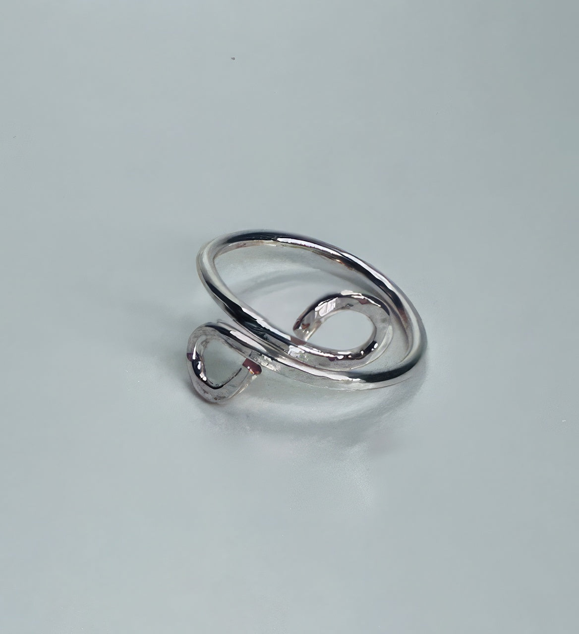 Handmade silver wire ring with two delicate swirls, hammered for super shiny texture