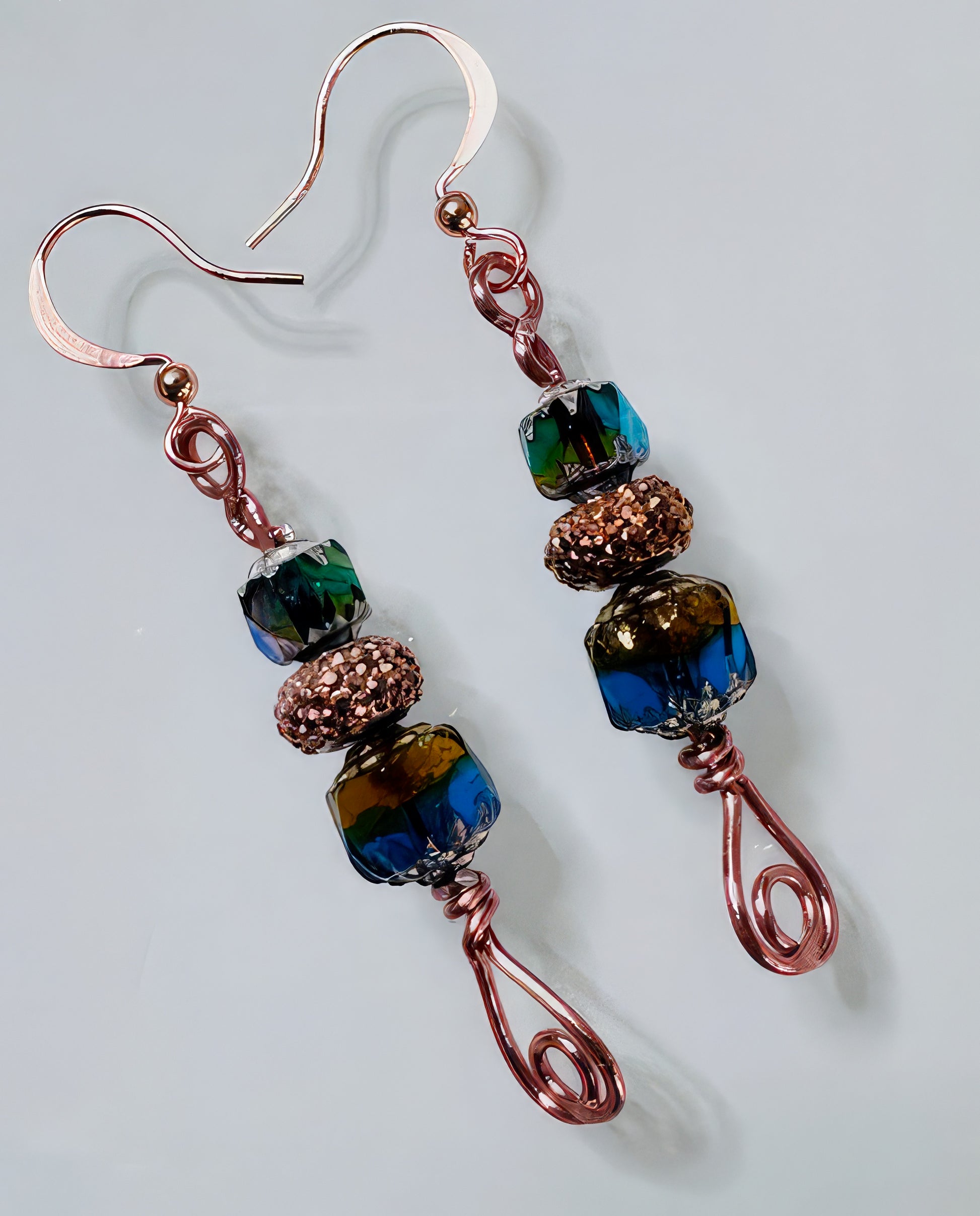 A pair of multicolored faceted Czech glass bead earrings with hand wrapped copper headpins and copper core wire, with a non-tarnish coating.