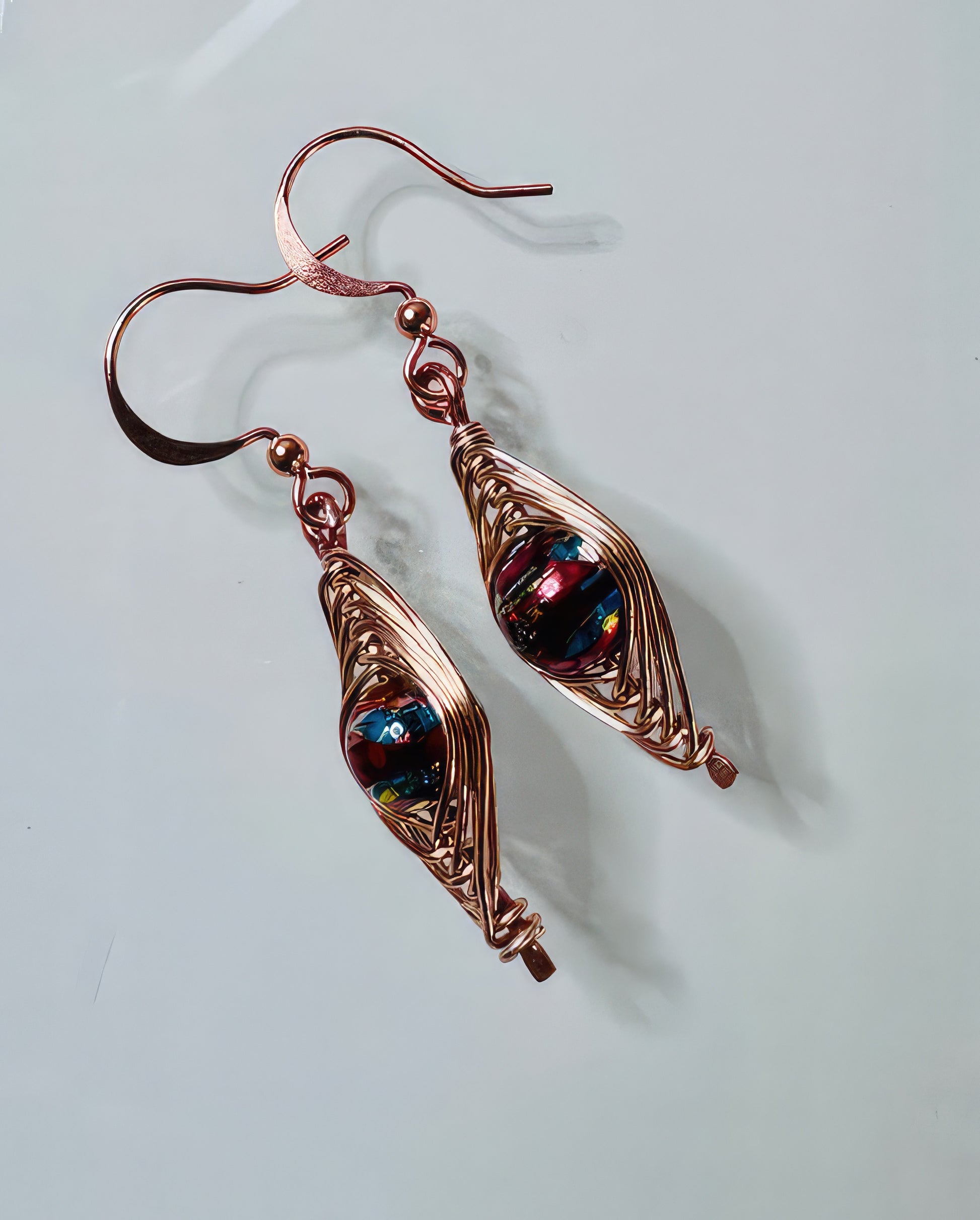 A pair of rose gold copper wire earrings with multicolor glass beads.