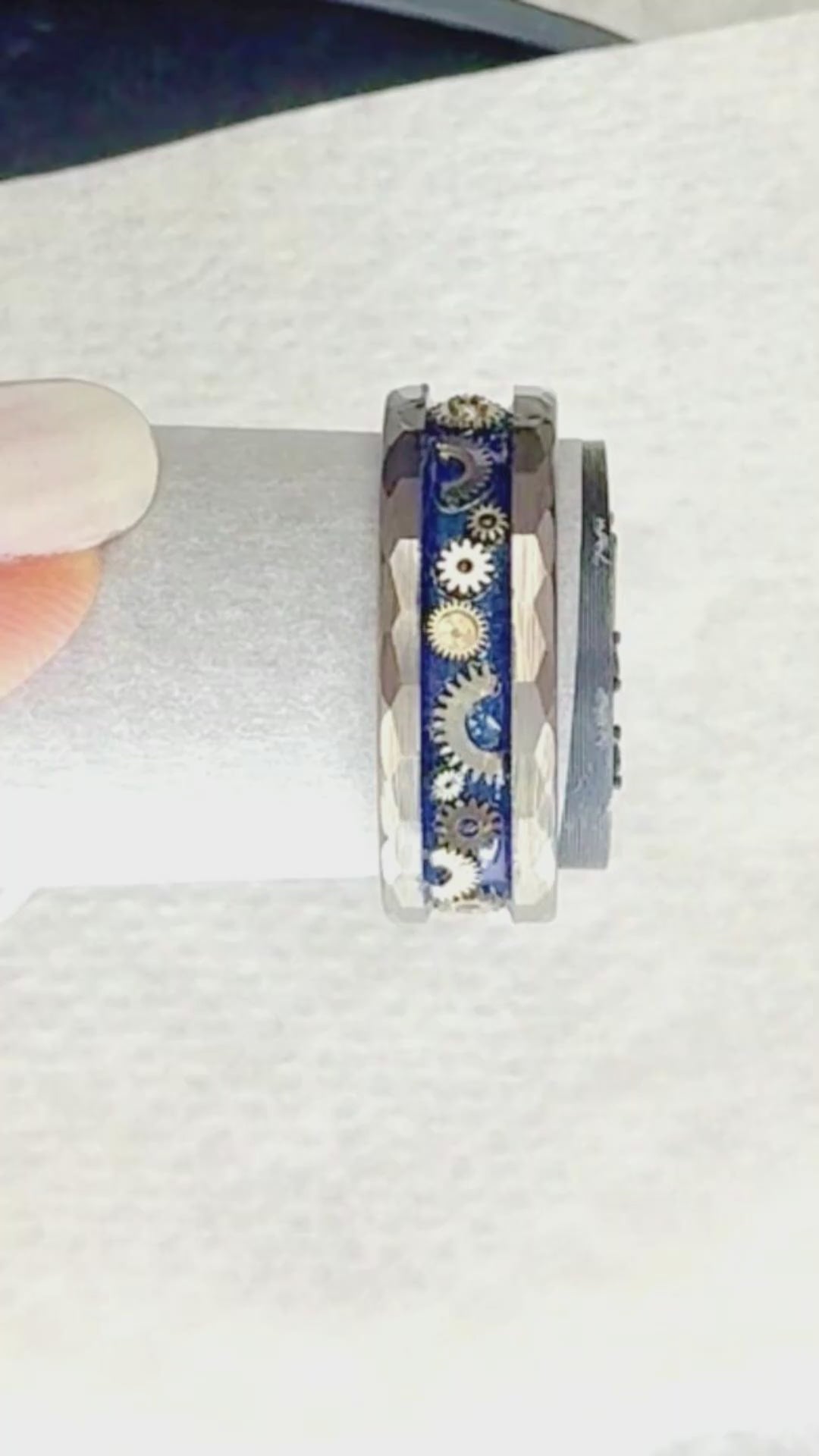 Video showing miniature vintage watch gears being individually placed into the Timekeeper tungsten ring by hand before the final crystal-clear finish is applied.